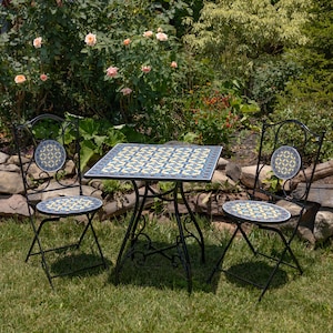 May include: A bistro set consisting of a square table and two folding chairs with black metal frames. The tabletop, chair seats, and chair backrests feature a decorative ceramic tile inlay with a repeating blue, yellow, and white geometric pattern.