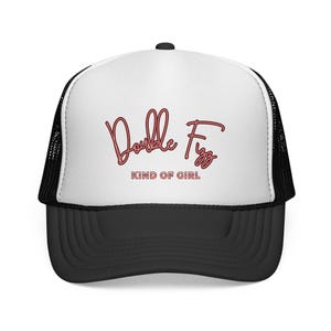 May include: A black and white trucker hat with a curved brim. The hat features a white front panel with the words "Double Fizz" in a cursive red font, and "KIND OF GIRL" in a smaller font below.