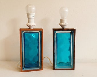 Two Swedish table lamps in solid pressed blue glass and teak wood "frame".