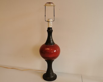May include: A red and black ceramic table lamp with a round shade. The lamp has a black base and a black cord.