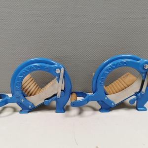 Puede incluir: Dos descorazonadores de manzanas de metal azul con inserciones de madera y una cuchilla plateada. Los descorazonadores están etiquetados con "RAD-VAR" en el lateral.