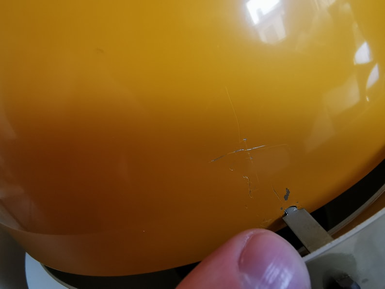May include: A yellow plastic lampshade with a crack in the surface.