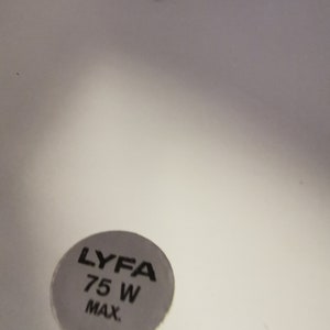 May include: A white ceiling fixture with a pink trim and a black sticker that reads "LYFA 75 W MAX."