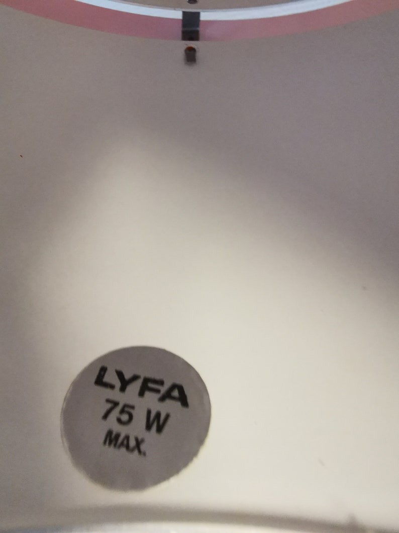 May include: A white ceiling fixture with a pink trim and a black sticker that reads "LYFA 75 W MAX."