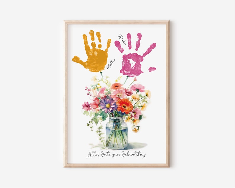 May include: A watercolor print with two handprints in yellow and pink, with the names "Mattea" and "Rike" written next to them. The handprints are above a bouquet of flowers in a glass jar. The text "Alles Gute zum Geburtstag" is at the bottom of the print.