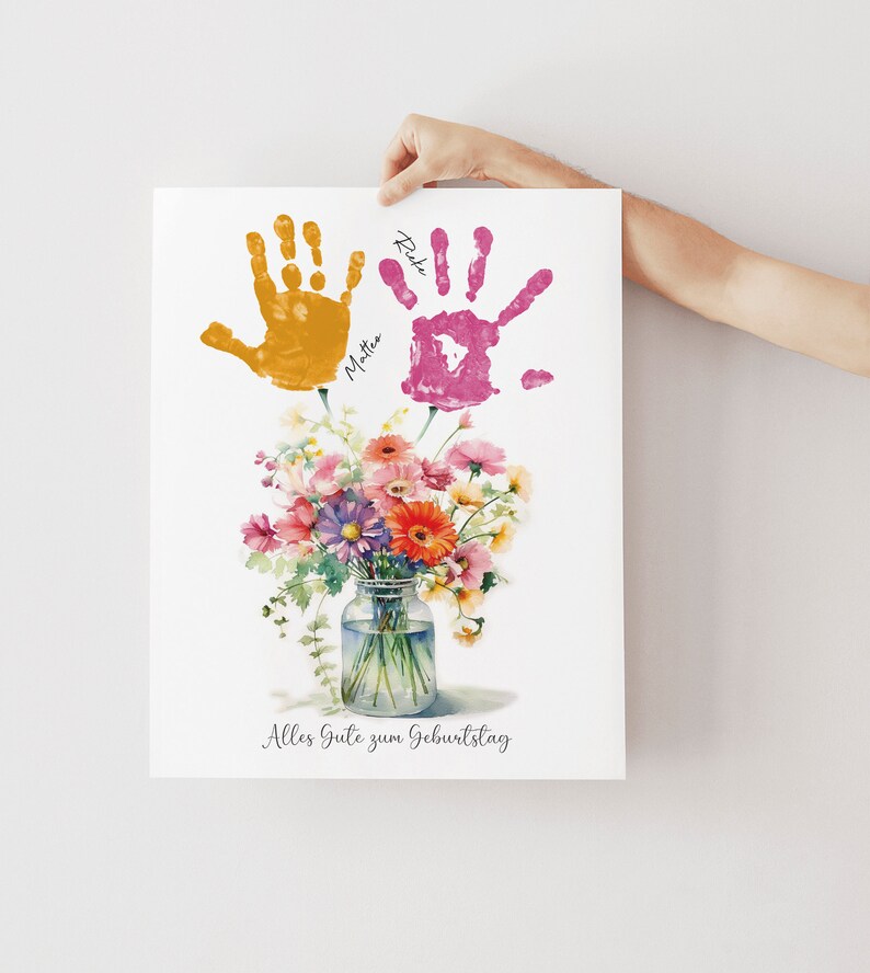 May include: A white card with a watercolor painting of a bouquet of flowers in a glass jar. The flowers are pink, orange, yellow, and purple. Two handprints are above the flowers, one yellow and one pink, with the names "Rike" and "Mattea" written next to them. The card says "Alles Gute zum Geburtstag" at the bottom.