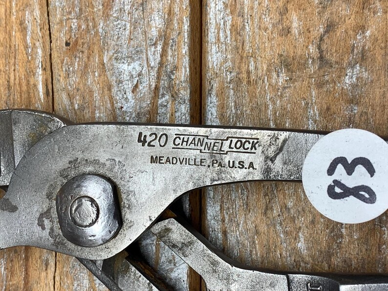K&ouml;nnte beinhalten: Nahaufnahme einer silberfarbenen Channel Lock 420 Zange. Der Text "CHANNEL LOCK" und "MEADVILLE, PA. U.S.A." sind sichtbar. Ein wei&szlig;er Aufkleber mit der Nummer "83" ist an der Zange angebracht.