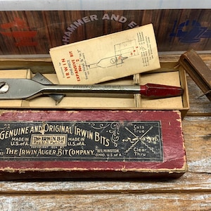 May include: An antique Irwin expansive bit set with original box and instructions. The box is red with black text, and the bit is silver with a red handle. A wooden tool is also present.