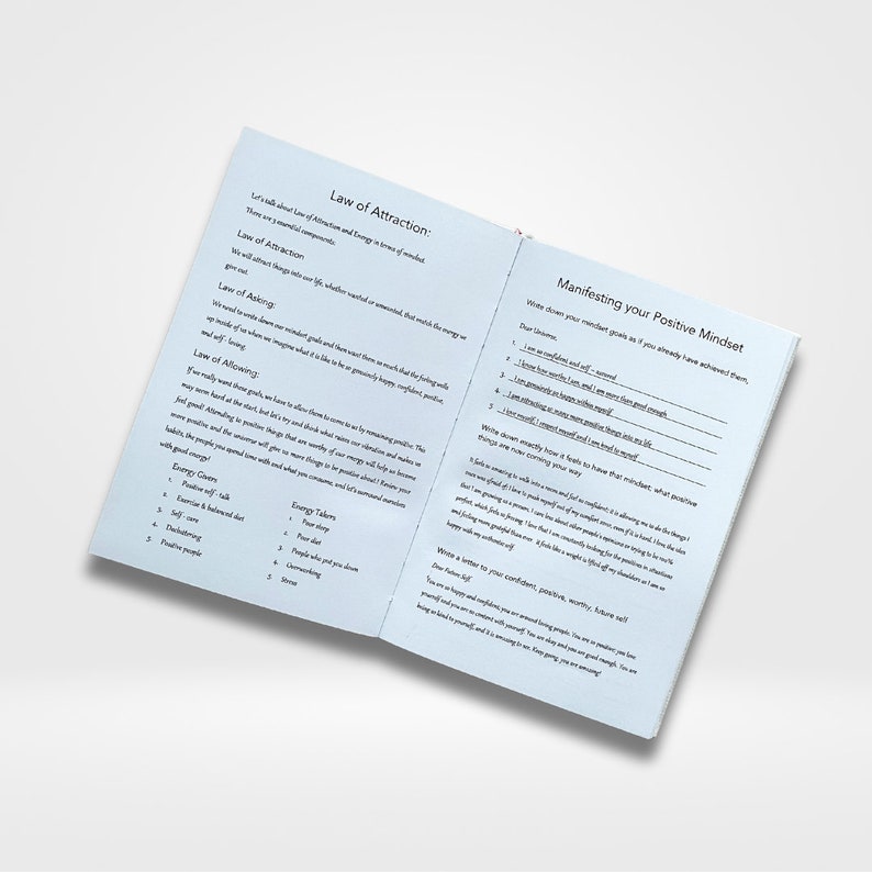 May include: An open book with blue pages and white text. The left page has the title "Law of Attraction" and lists the "Law of Asking", "Law of Allowing", and "Energy Givers". The right page has the title "Manifesting your Positive Mindset" and lists affirmations to write down.
