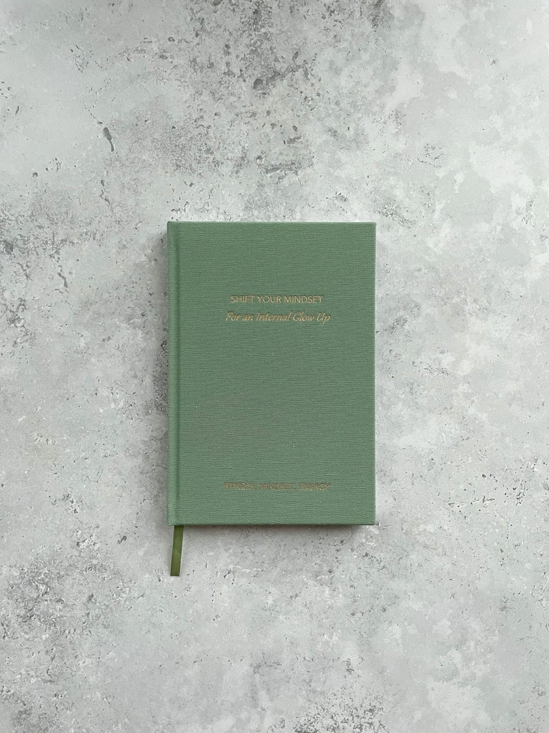 May include: A green journal with the text "Shift Your Mindset for an Internal Glow Up" on the front cover.