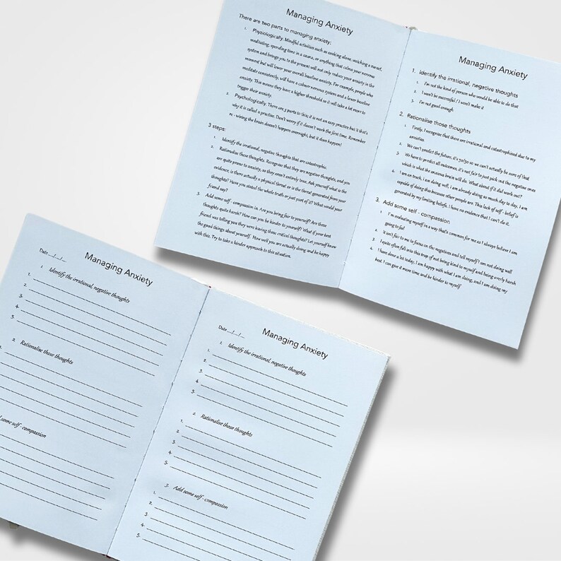 May include: A blue and white journal with the title "Managing Anxiety" on the cover. The journal is open to a page with instructions on how to manage anxiety. The instructions include identifying negative thoughts, rationalizing those thoughts, and adding self-compassion.