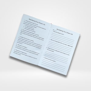 May include: A blue and white journal with the title "Manifesting Your Dream Life" on the cover. The journal has lined pages for writing and includes prompts to help you manifest your dreams.