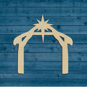 May include: A wooden cutout of a nativity scene manger with a star on top. The manger is a simple design with two posts and a curved roof. The star is a five-pointed star with a long point at the top.