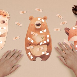 Può includere: Un'illustrazione stravagante presenta un riccio, un orso e una volpe, ognuno adornato con adesivi a forma di cerotto. L'orso tiene dei fiori. Cerotti numerati sono sparsi intorno agli animali. L'immagine ha una tavolozza di colori morbida.