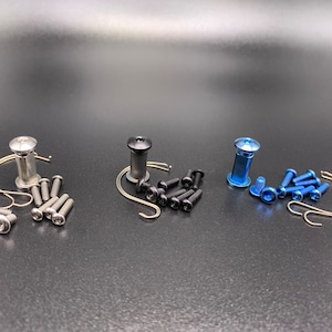 May include: Three sets of hardware for furniture assembly. Each set includes a silver, black, or blue metal knob, a metal hook, and several screws.