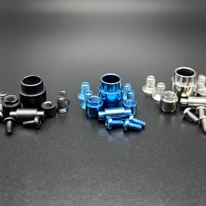 May include: Three sets of hardware for a bicycle, each set includes a black, blue, or silver spacer, along with screws and nuts.