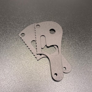 May include: Three black metal cutouts with intricate designs, resembling a keyhole and a small handle, stacked on top of each other.