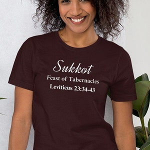 Może przedstawiać: Bordowy t-shirt z białym napisem "Sukkot Święto Namiotów Księga Kapłańska 23:34-43".
