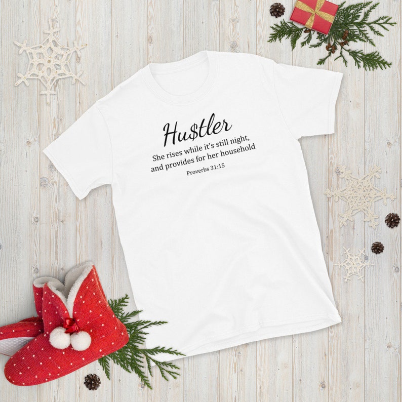 May include: White t-shirt with black text that reads "Hustler" and a quote from Proverbs 31:15. The quote reads "She rises while it's still night, and provides for her household".