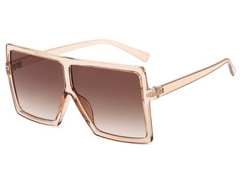 May include: Oversized square sunglasses with a brown gradient lens and a light brown frame.