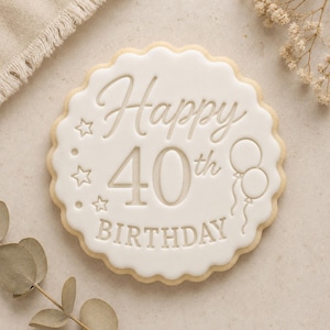 May include: A round, scalloped-edge sugar biscuit with smooth white icing. The centre features embossed text reading Happy 40th BIRTHDAY, accompanied by three small stars on the left side and two balloon outlines on the right side of the biscuit.