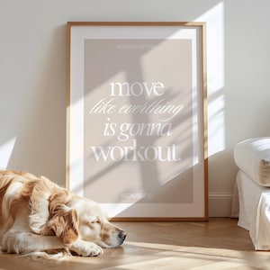 Könnte beinhalten: Gerahmtes Poster mit dem Text "move like everything is gonna workout" in weißer Schrift. Das Poster hat einen hellbraunen Rahmen und einen beigen Hintergrund. Ein Golden Retriever liegt auf dem Holzboden vor dem Poster.