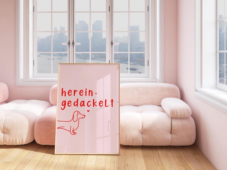 May include: A pink framed poster with a red dachshund illustration and the text "herein-gedackelt" on a pink background.
