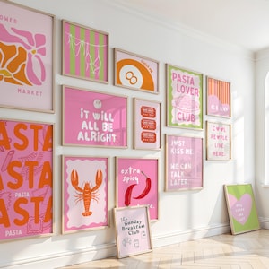 May include: A collection of framed art prints in pink, orange, and green. The prints feature various designs, including text, food illustrations, and abstract shapes. The phrases include "Pasta Lover Club", "It Will All Be Alright", and "Just Kiss Me."