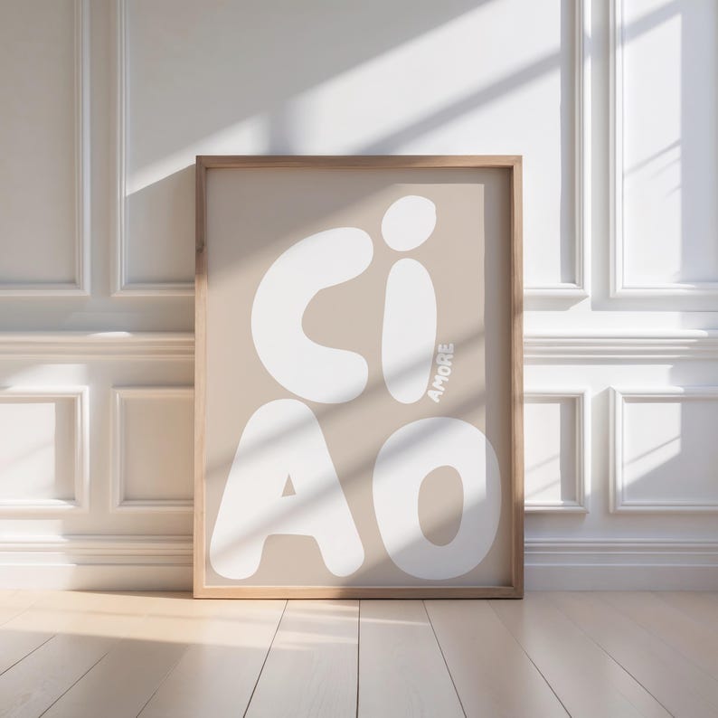 K&ouml;nnte beinhalten: Ein gerahmter Kunstdruck mit dem Wort "CIAO" in gro&szlig;en, wei&szlig;en, abgerundeten Buchstaben auf beigem Hintergrund. Das Wort "AMORE" ist vertikal in Wei&szlig; gedruckt. Der Rahmen besteht aus hellbraunem Holz.