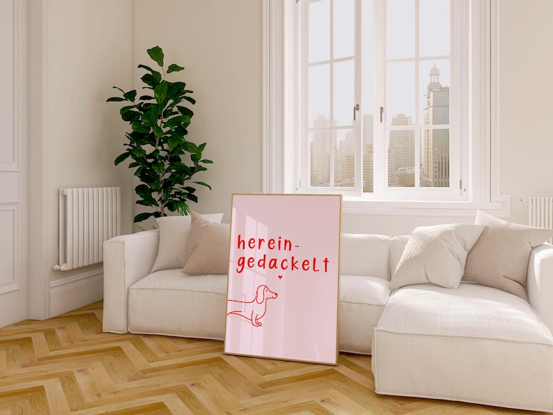 May include: A pink poster with a red dachshund illustration and the text "herein-gedackelt" in red.