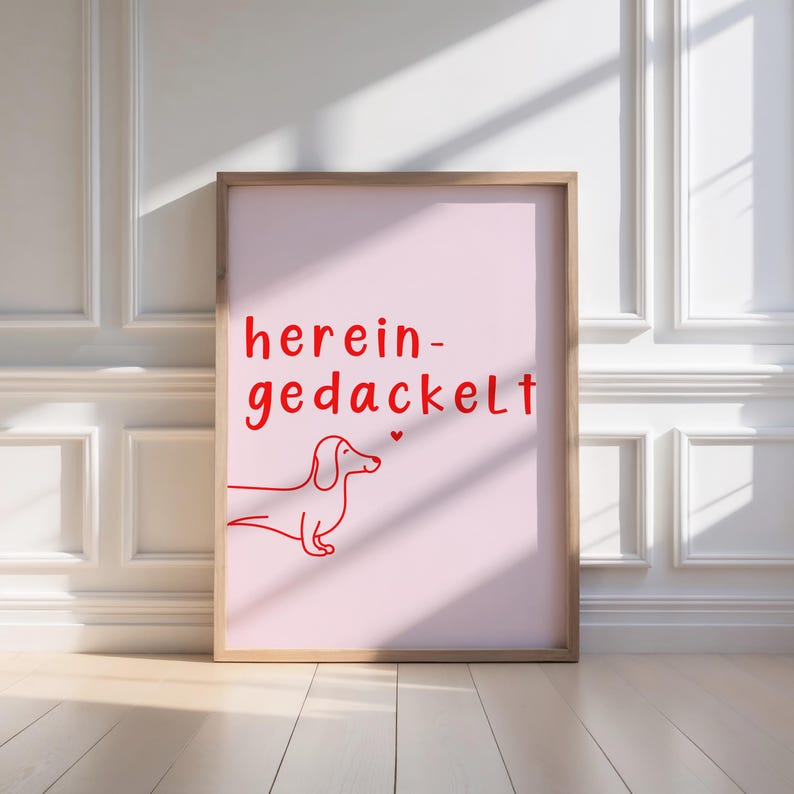 May include: A pink poster with a red dachshund illustration and the text "herein-gedackelt" in red.