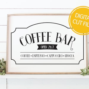 Könnte beinhalten: Ein weißes Schild mit schwarzem Rahmen und dem Text "Coffee Bar" in einer dekorativen Schriftart. Das Schild enthält auch den Text "Open 24/7" und "Coffee - Espresso - Cappuccino - Mocha".