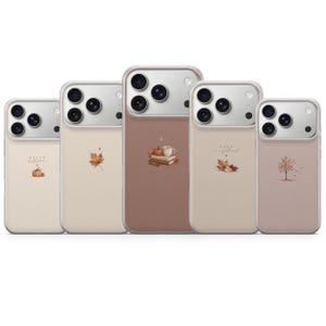May include: Five smartphone cases in varying shades of beige and brown, each featuring a unique autumn-themed graphic. Designs include a pumpkin with the text 'HELLO autumn', a maple leaf, a stack of books with a mug, leaves with 'FALL is in a good mood', and a tree.