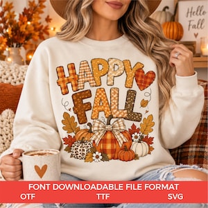 Op de afbeelding: Een crèmekleurig sweatshirt met ronde hals en de tekst HAPPY FALL in een mix van ruitjes, stippen en luipaardprint. Onder de tekst staan drie pompoenen in oranje, wit en luipaardprint, versierd met herfstbladeren en een strik.