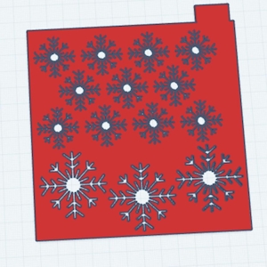 May include: A red rectangular card with a small tab at the top. The card is decorated with dark blue snowflakes with white centers. Three large snowflakes are at the bottom, and smaller ones are arranged in rows above.