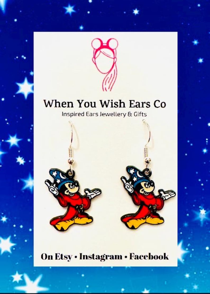 Puede incluir: Un par de pendientes colgantes de plata con un dise&ntilde;o de dibujos animados de Mickey Mouse mago. Los pendientes son rojos, amarillos, azules y negros. El texto "When You Wish Ears Co" e "Inspired Ears Jewellery & Gifts" est&aacute; sobre un fondo blanco. El texto "On Etsy, Instagram, Facebook" est&aacute; en la parte inferior de la imagen.