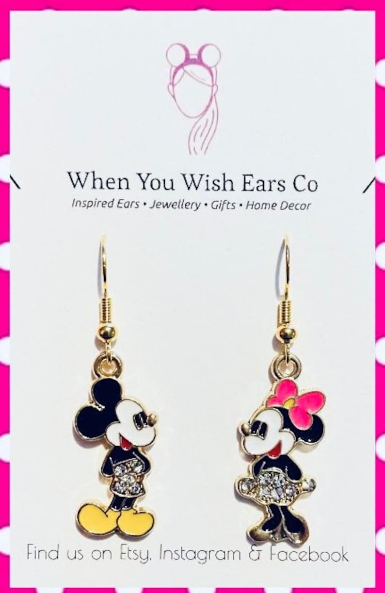 Puede incluir: Pendientes de aro dorados con Mickey y Minnie Mouse. Los pendientes tienen esmalte negro y blanco con pedrer&iacute;a y detalles rosas.