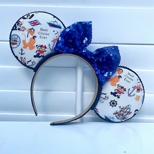 May include: Headband with a blue sequin bow and white fabric ears featuring Disney characters and the text "Best Cruise Ever".
