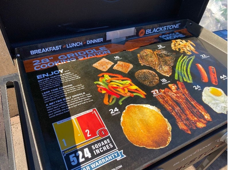 May include: Blackstone 28 inch griddle cooking station with a graphic showing different foods that can be cooked on the griddle. The griddle has a 524 square inch cooking surface and comes with a 1 year warranty.