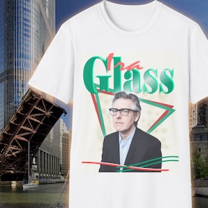 May include: White t-shirt with a green and red graphic design featuring a man wearing glasses and the text "The Glass".