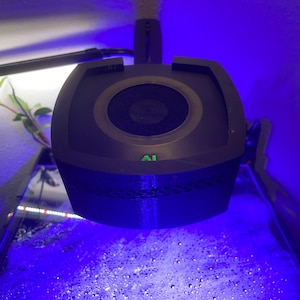 May include: A black aquarium light with a round, white, mesh-covered lens. The light is mounted on a black arm and is casting a blue light on the water below.