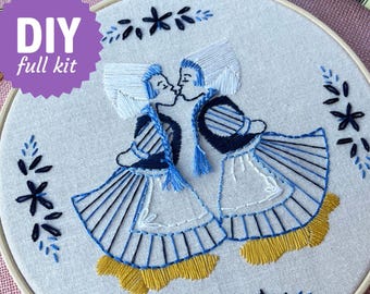 May include: A DIY embroidery kit featuring a design of two figures kissing, dressed in traditional attire. The figures are embroidered in shades of blue, white, and yellow on a light fabric, framed in a wooden hoop. The kit includes the text "DIY full kit".