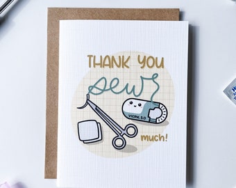May include: A white card with a brown envelope behind it. The card has a grid pattern and says "Thank you sew much!" in gold lettering. There is a cartoon illustration of a suture needle, a pair of forceps, and a pill with a happy face. The pill says "Vicryl 5.0" on it.