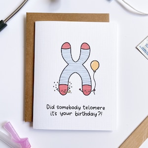 Puede incluir: Una tarjeta de cumpleaños con una ilustración de dibujos animados de un cromosoma sosteniendo un globo. El texto en la tarjeta dice "Did somebody telomere it's your birthday?!"