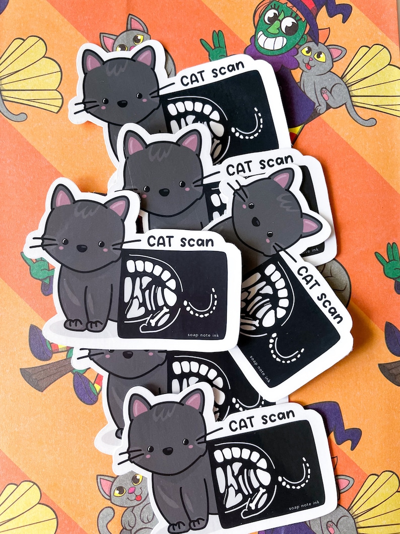 May include: A stack of black and white cat scan stickers with a cartoon cat on each sticker. The stickers say "CAT scan" and "soap note ink".
