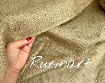 May include: Close-up of a tan burlap fabric with a coarse, woven texture. The fabric is folded, revealing its depth and natural color variations. The word "Rurinart" is written in white script across the fabric.