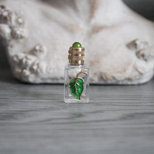 Tom miniatyr parfymflaska i glas, 3,6 cm, bladdesign, guldkork med grön pärla