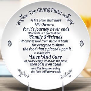 May include: White ceramic plate with a blue inscription that reads "The Giving Plate. This plate shall have No Owners for it's journey never ends. It travels in a circle of our Family & Friends. It carries love from home to home for everyone to share the food that's placed upon it is made with Love And Care. So please enjoy what's on the plate then pass it on again and if it keeps on going the love will never ends."