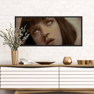 May include: A close-up of a woman's face with dark hair and a black eye. She is looking up with a serious expression. The image is in a black frame.