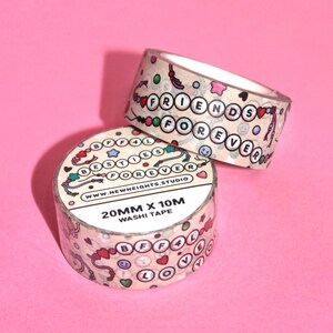 May include: Two rolls of washi tape with a light brown background and colorful designs. The tape features the words "Best Friends Forever" and "BFF4L" with hearts, stars, and smiley faces. The tape is 20mm wide and 10m long.